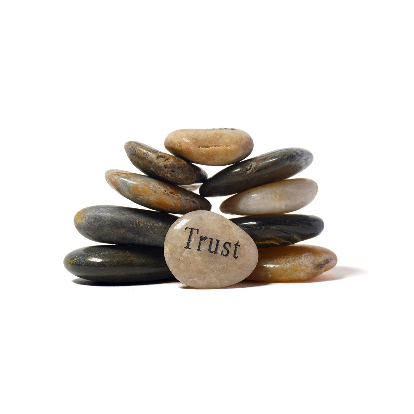 Stack of stones with 'Trust' engraved on the bottom stone against a white background