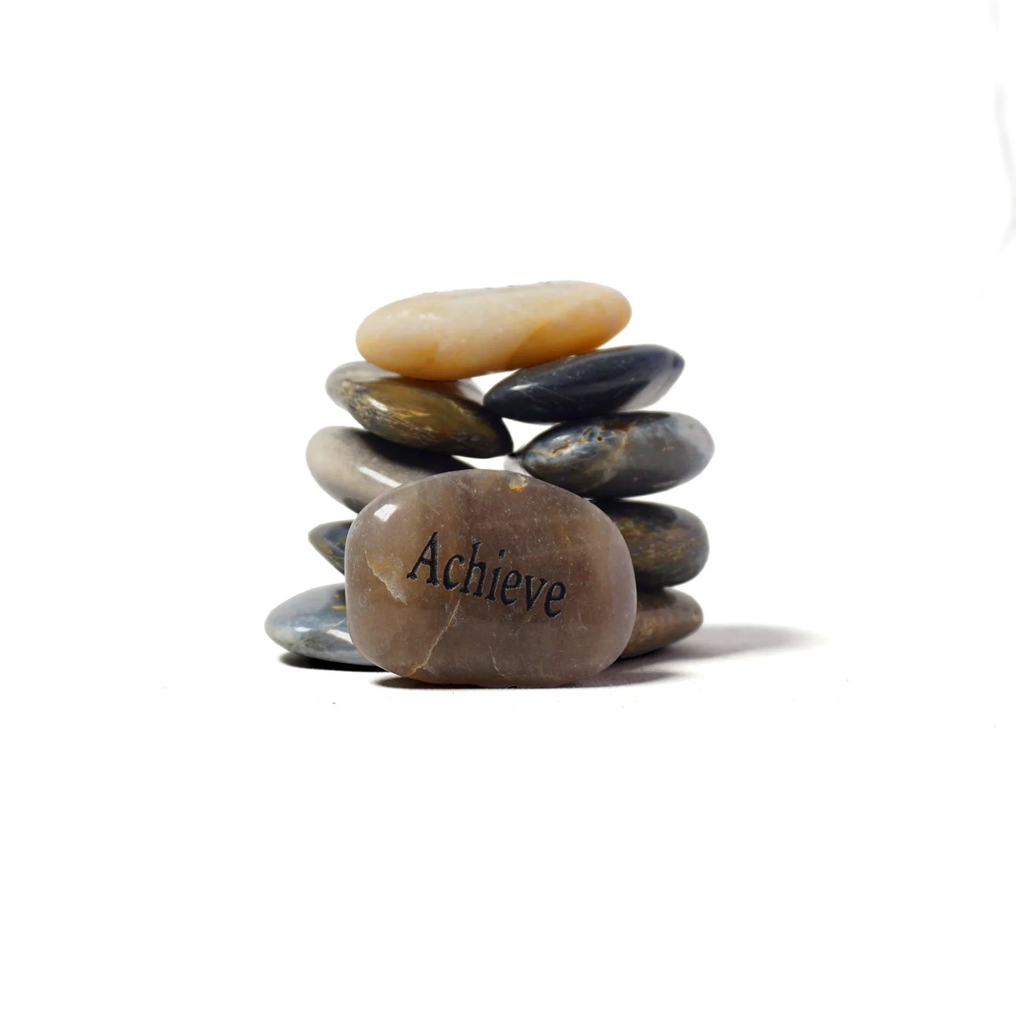 Stack of stones with 'Achieve' engraved on a white background