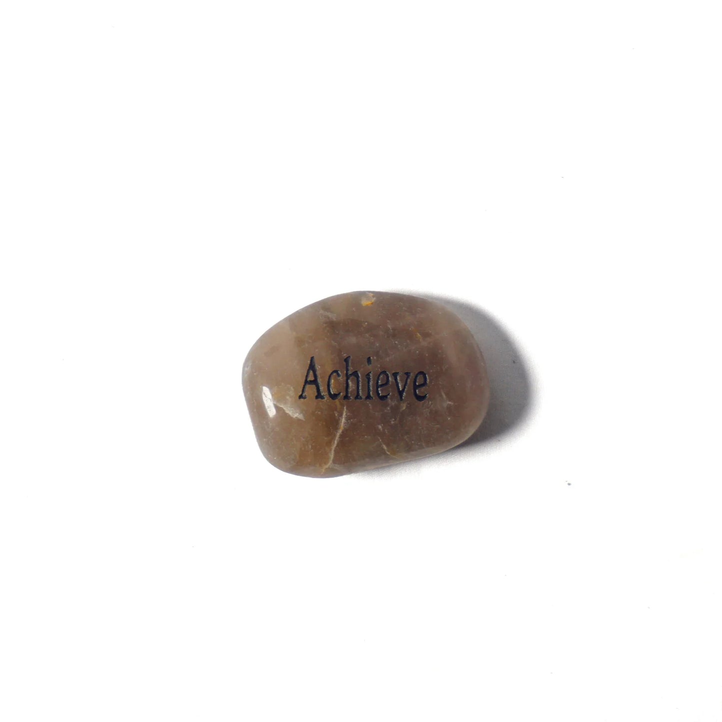 Brown stone with 'Achieve' engraved on a white background