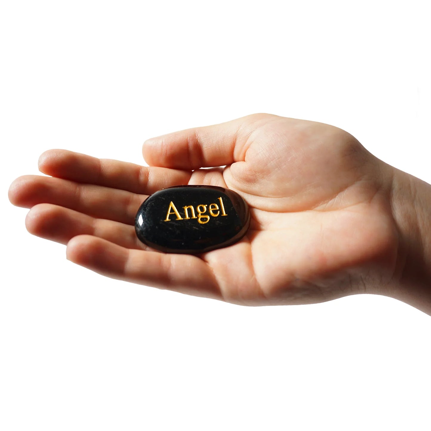 Hand holding a black stone with 'Angel' engraved on it against a white background