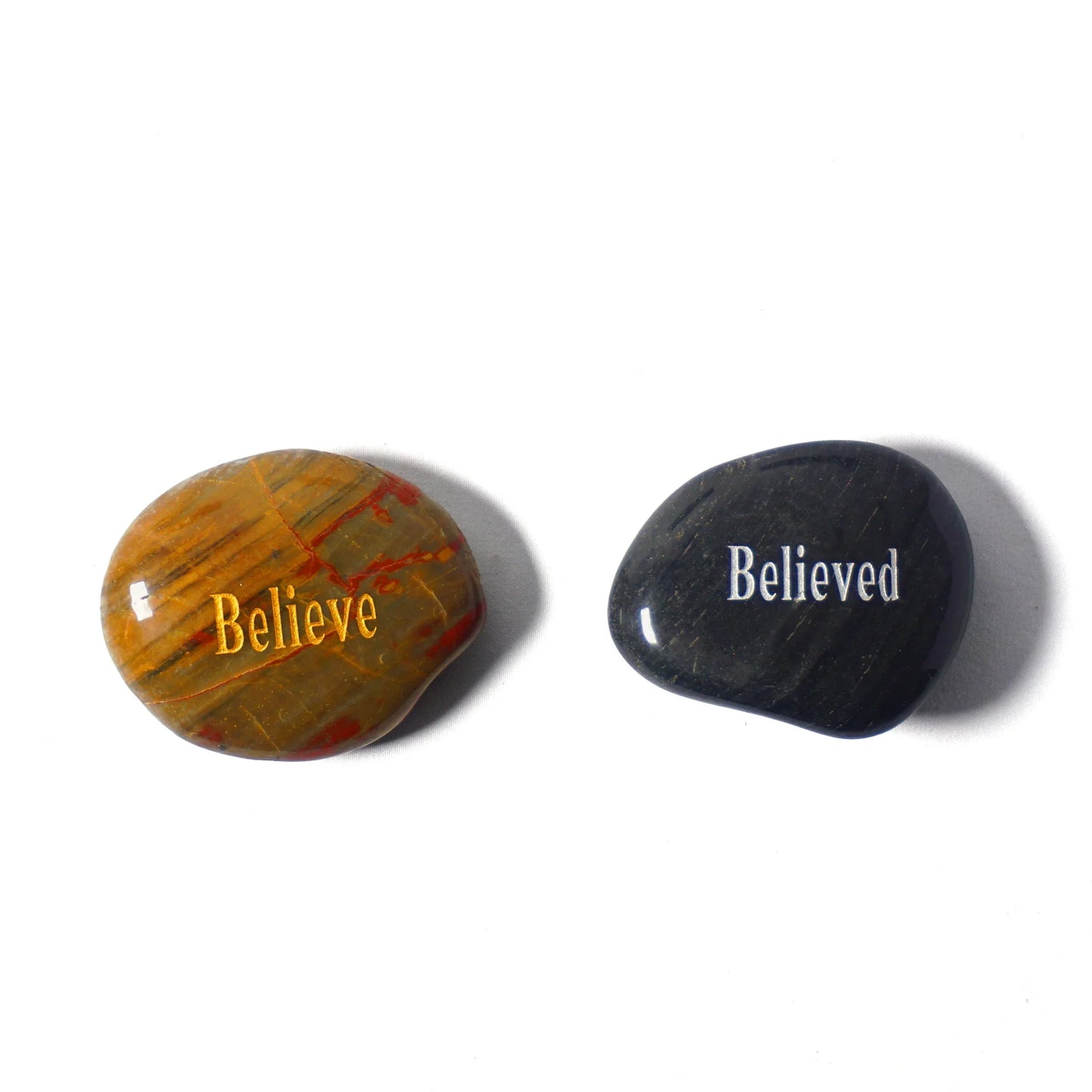 Two stones, one with 'Believe' and the other with 'Believed', on a white background.