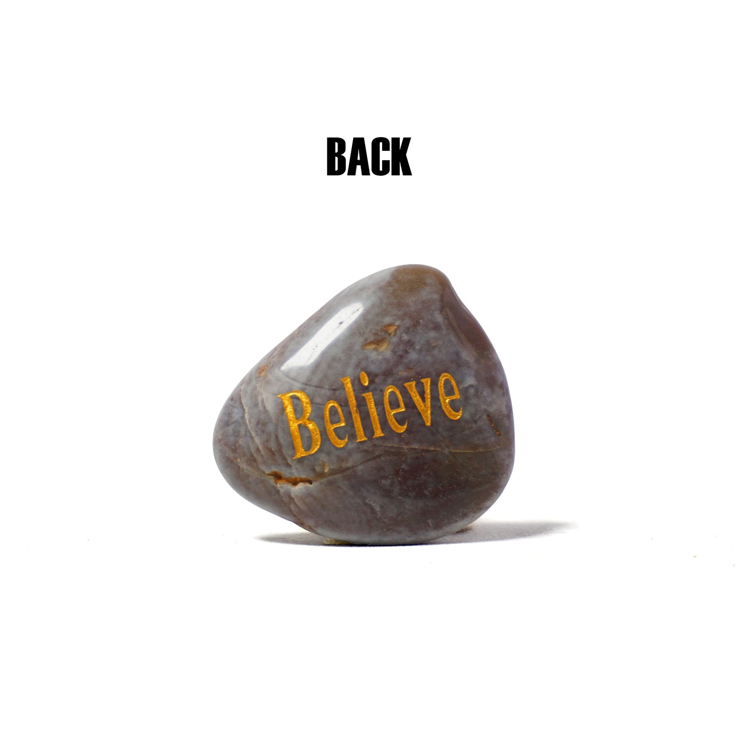 Rocks with 'Believe' engraved on a white background