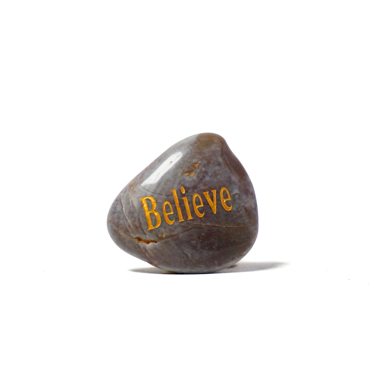 Rock with 'Believe' engraved on a white background