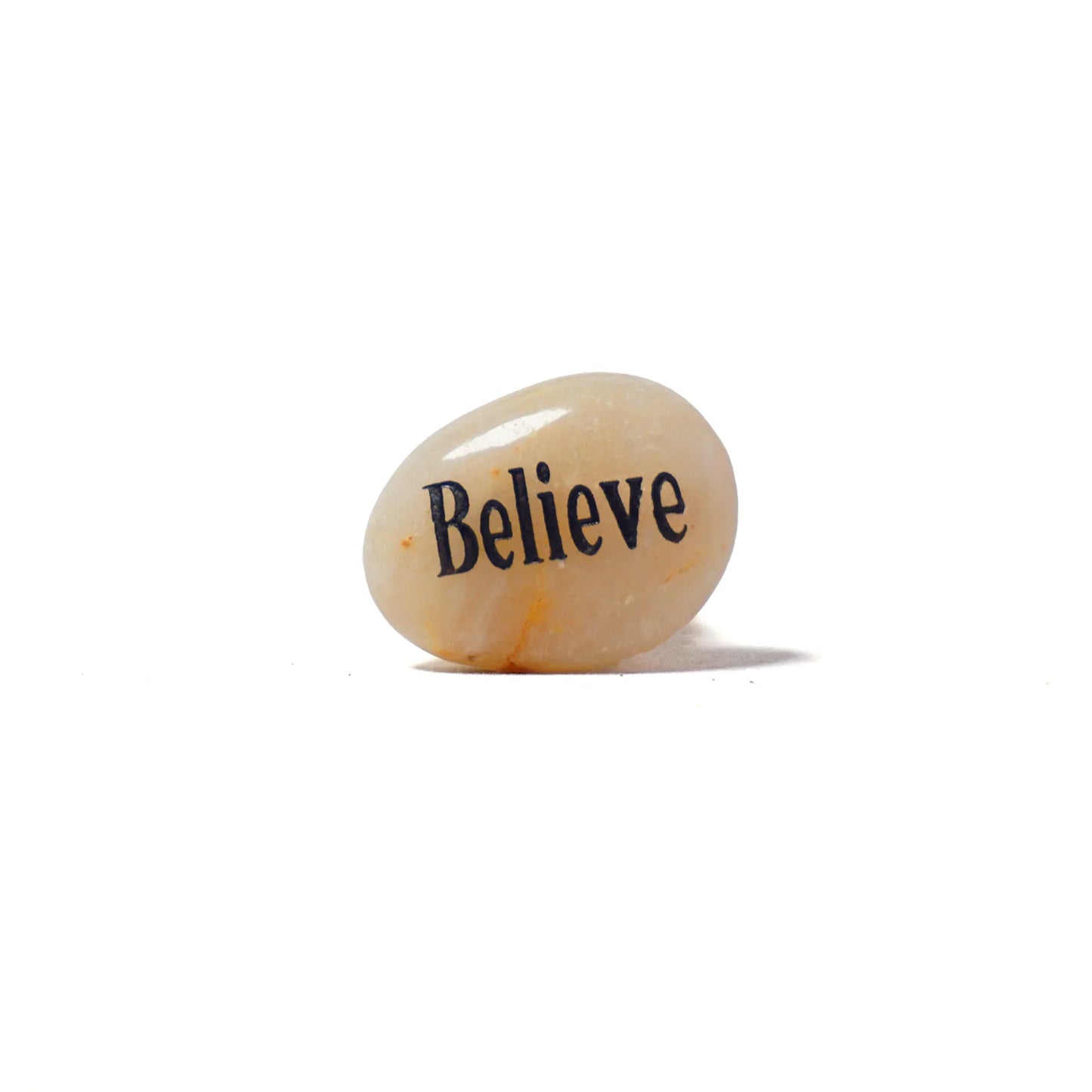 Decorative stone with 'Believe' engraved on a white background