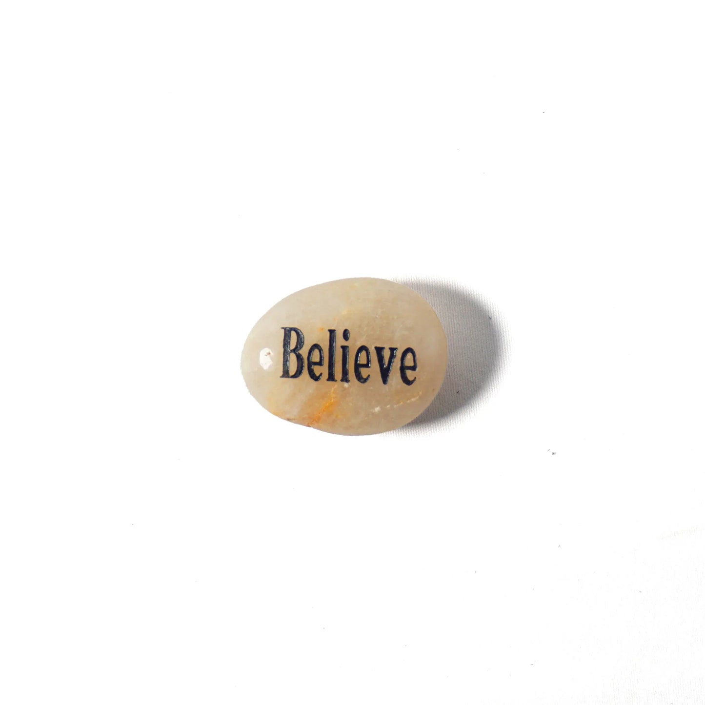 Small stone with 'Believe' engraved on a white background