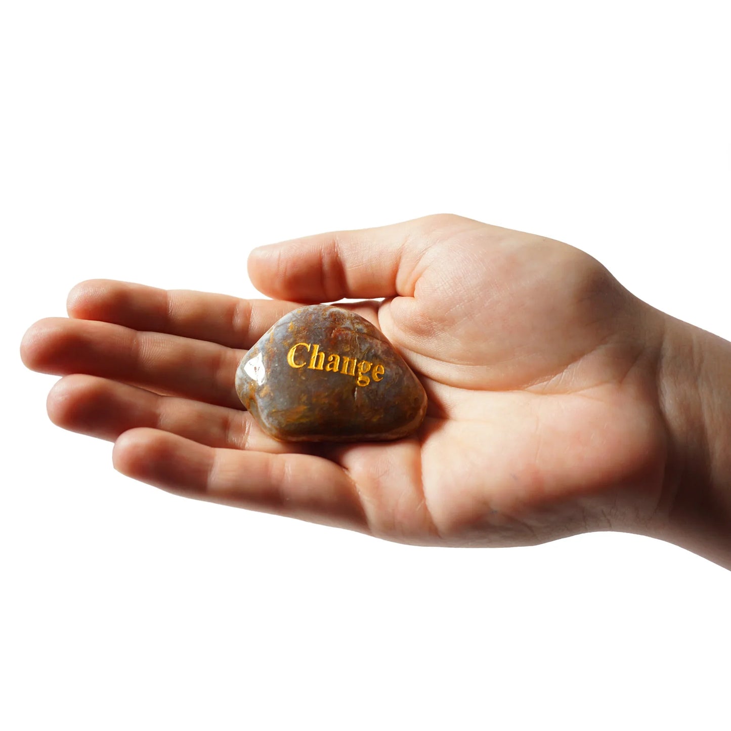 Hand holding a rock with 'Change' engraved on it against a white background
