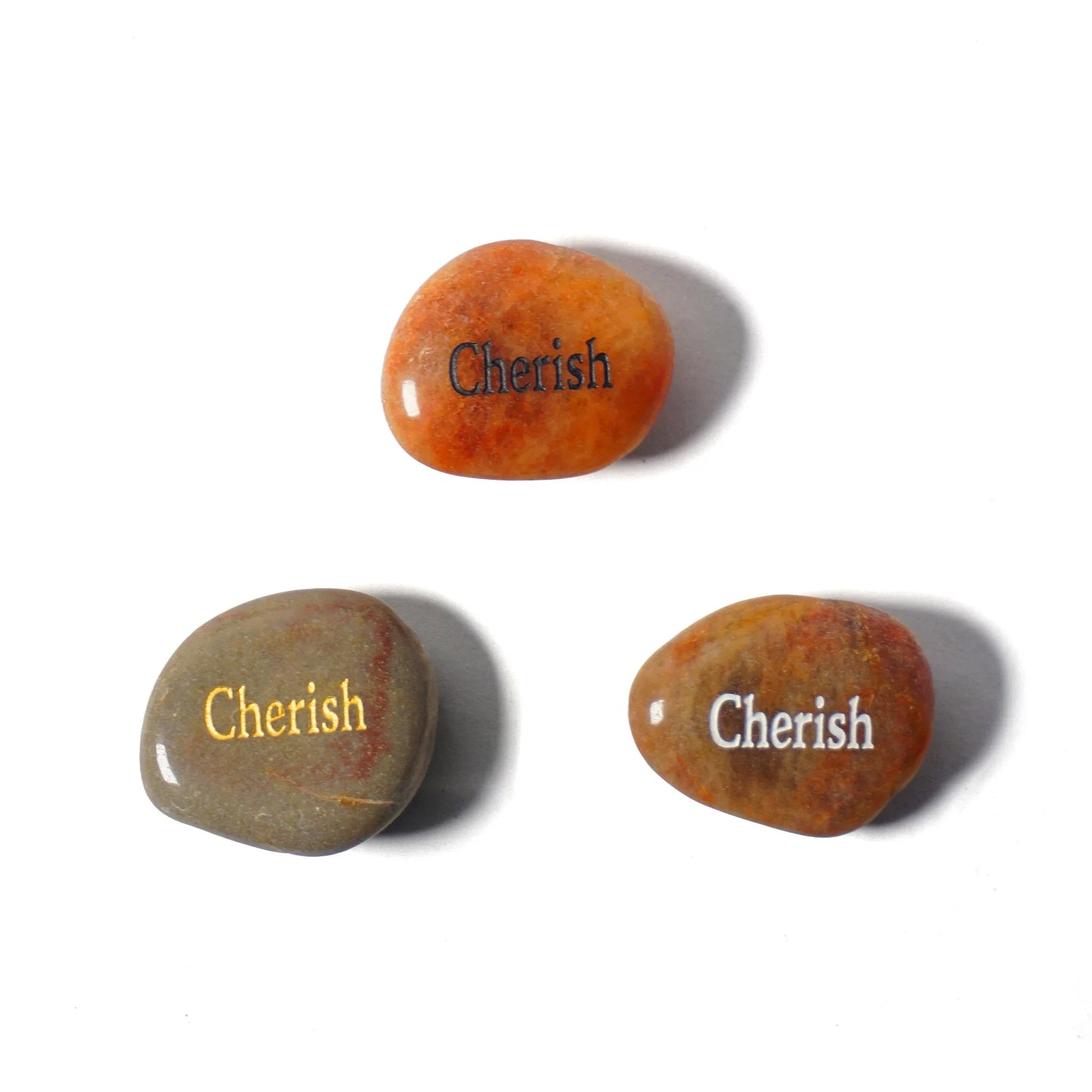 Three stones with 'Cherish' engraved on them on a white background