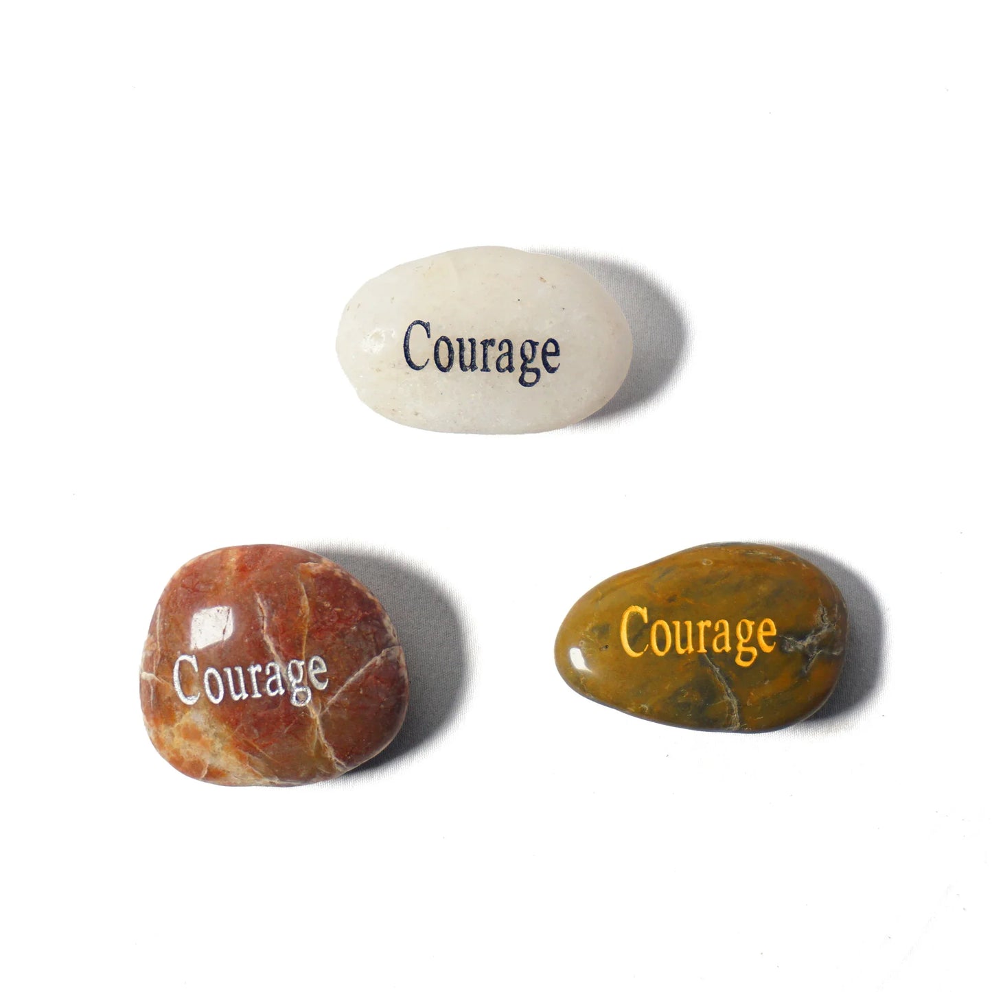 Three stones with 'Courage' engraved on them on a white background