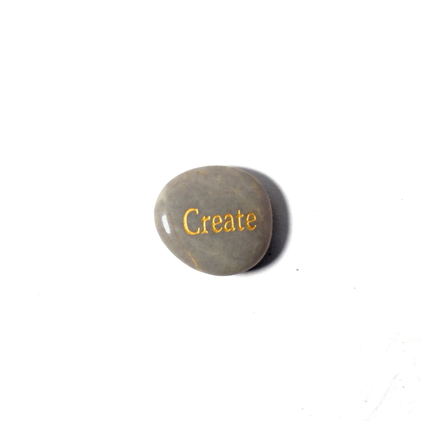 Round stone with 'Create' engraved on a white background