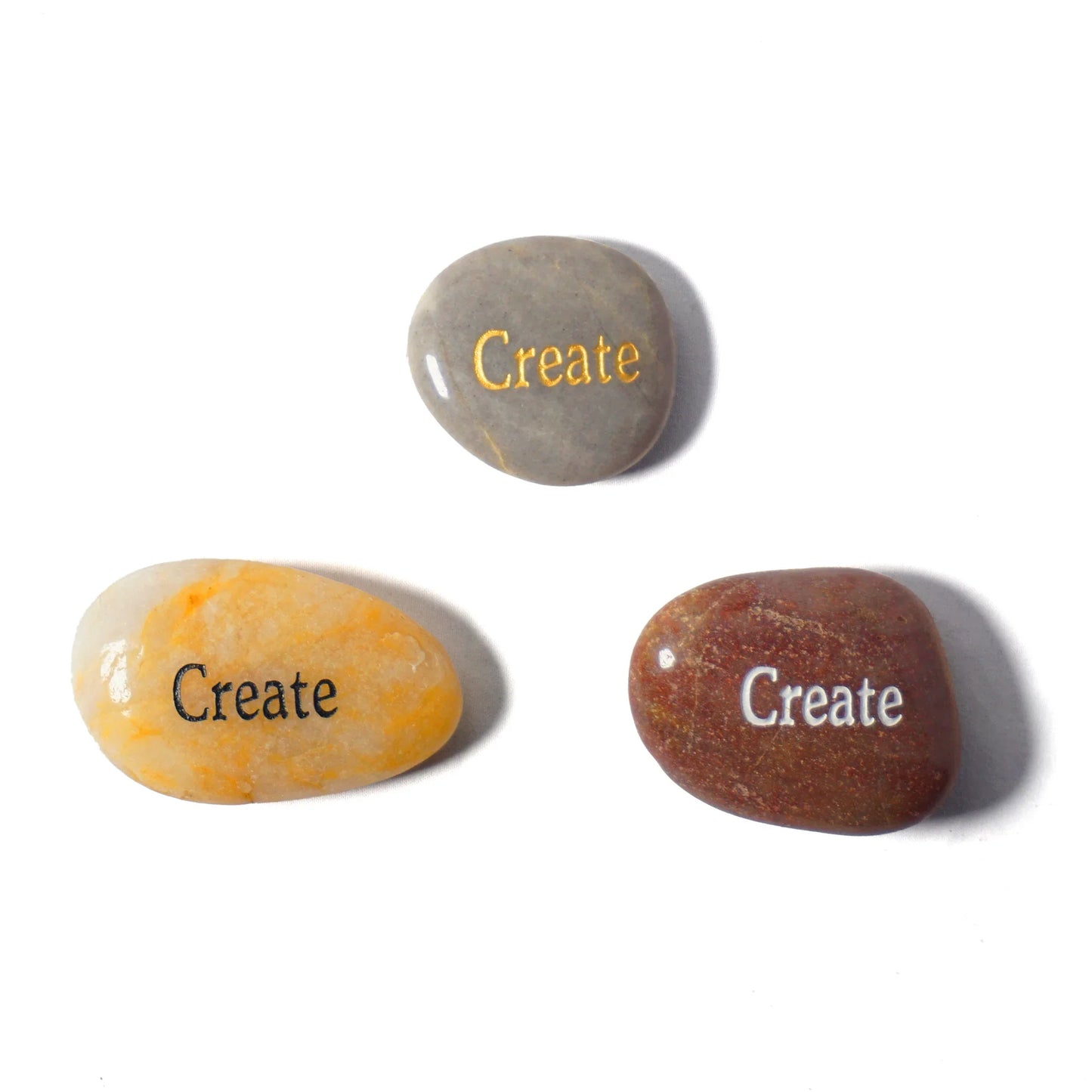 Three stones with 'Create' engraved on them on a white background