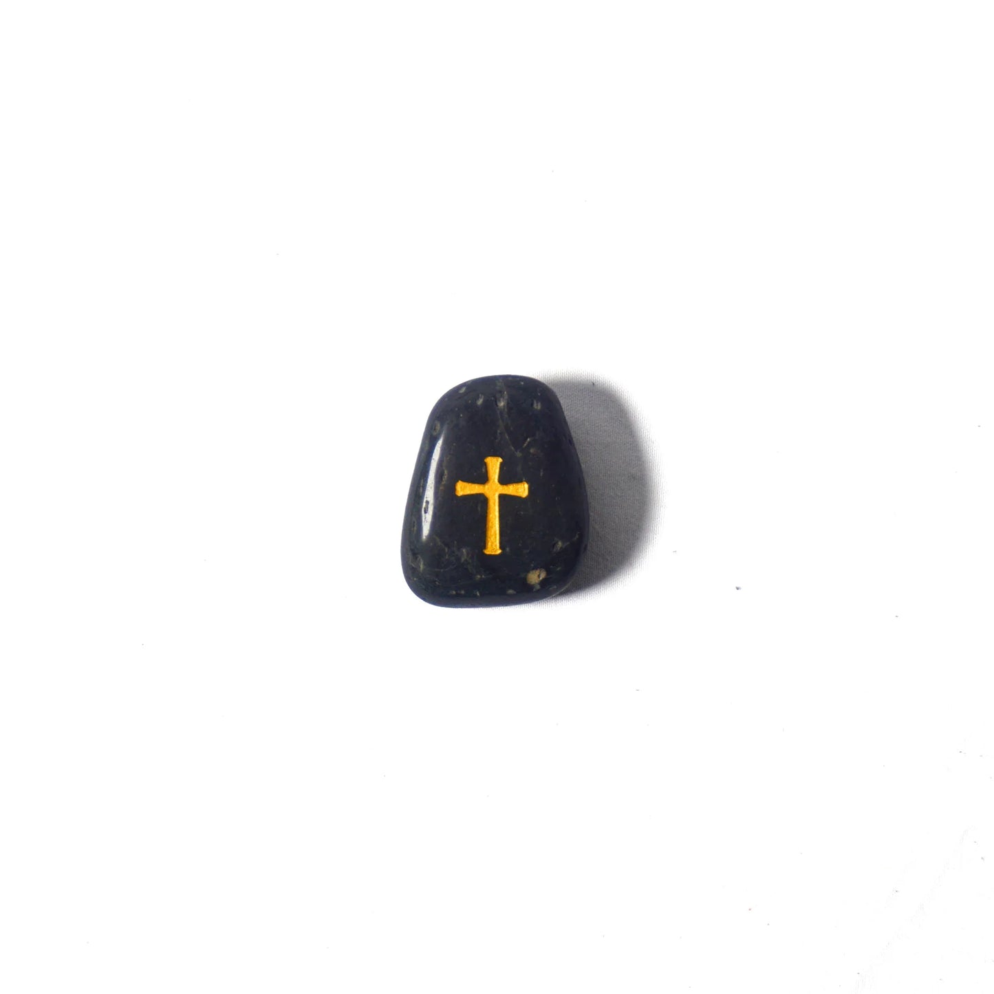 Black stone with a gold cross on a white background
