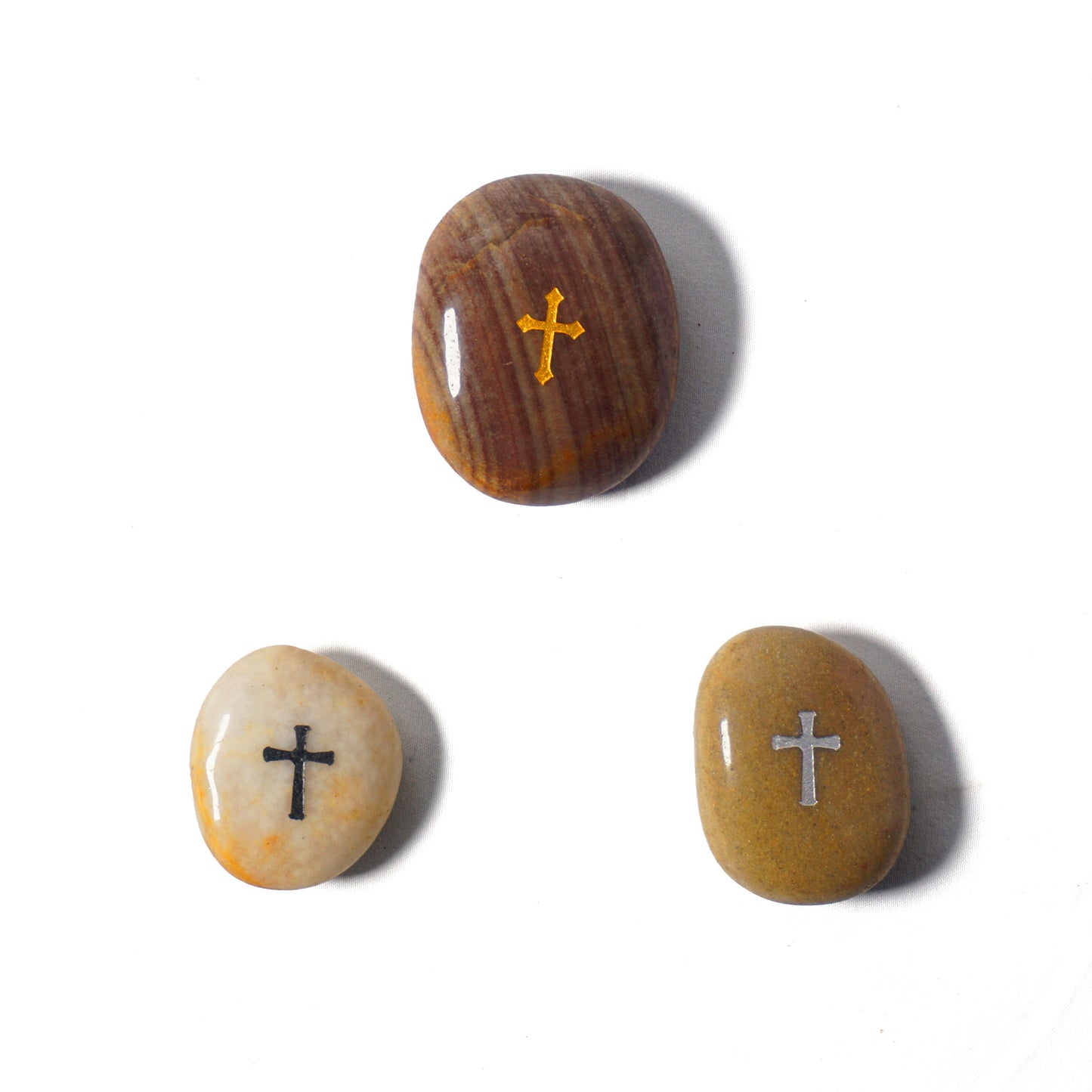 Three stones with crosses engraved on them on a white background