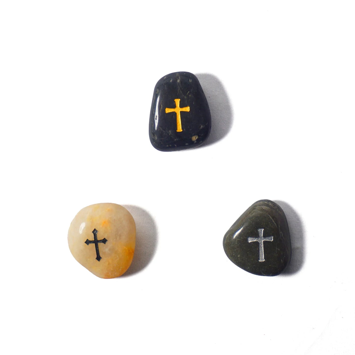 Three stones with crosses engraved on them on a white background