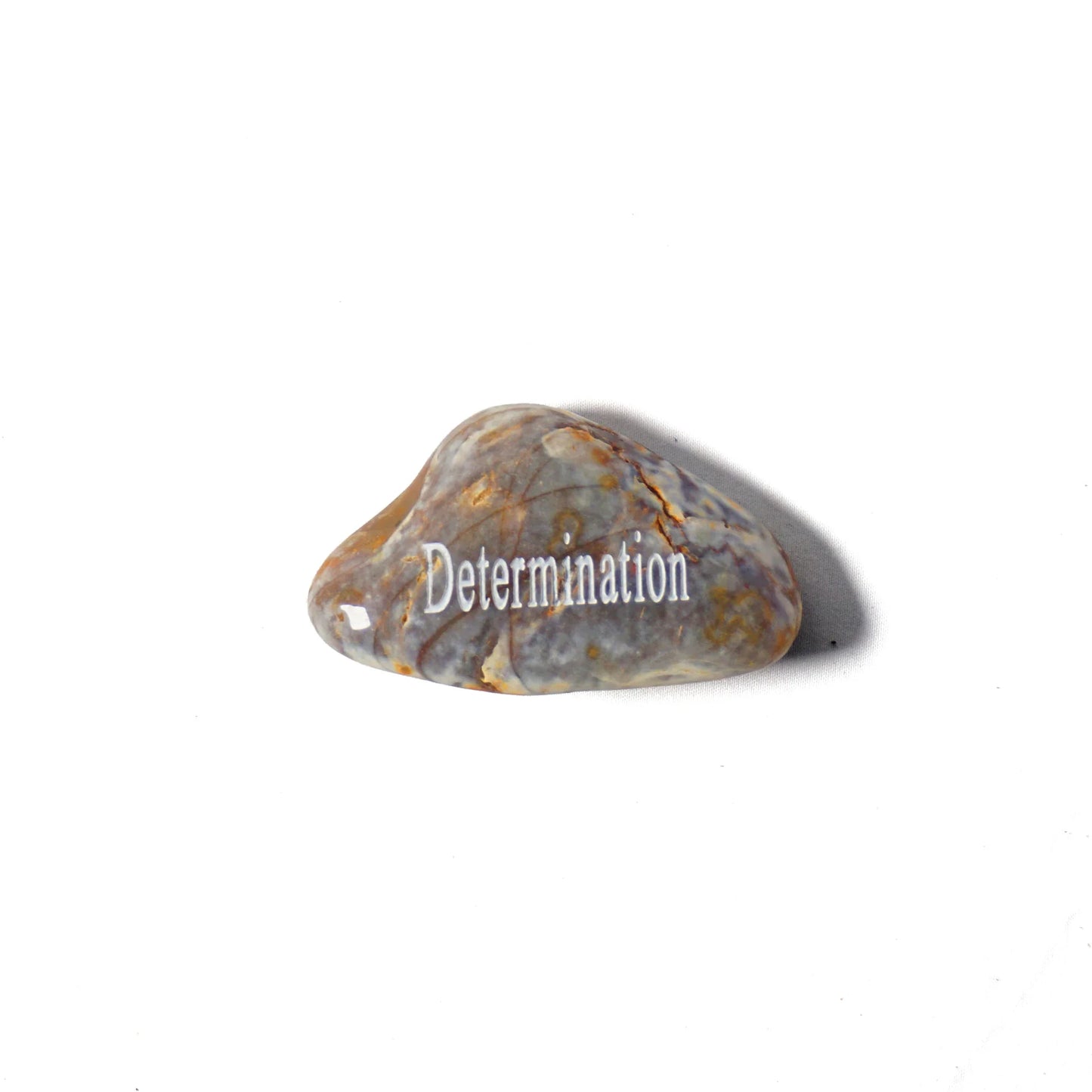 Heart-shaped stone with 'Determination' engraved on a white background