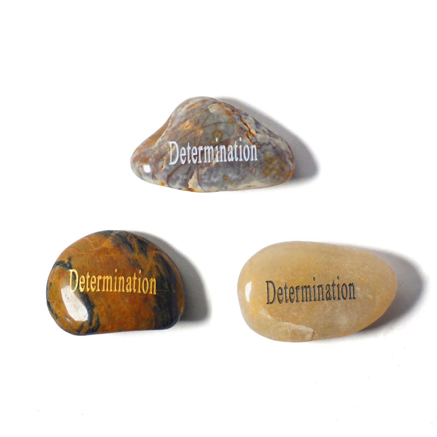 Three stones with 'Determination' engraved on them on a white background