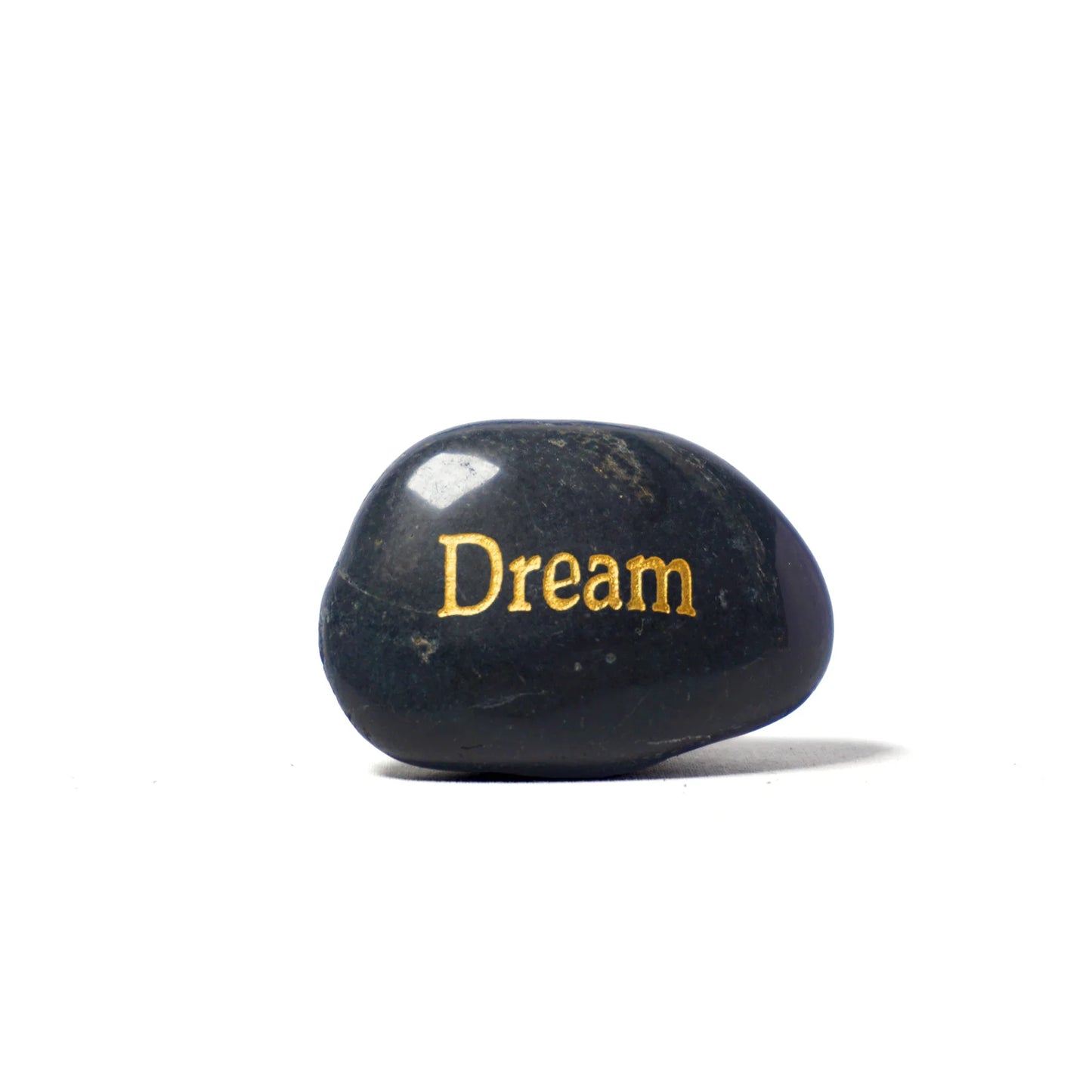 Black stone with 'Dream' engraved in gold on a white background