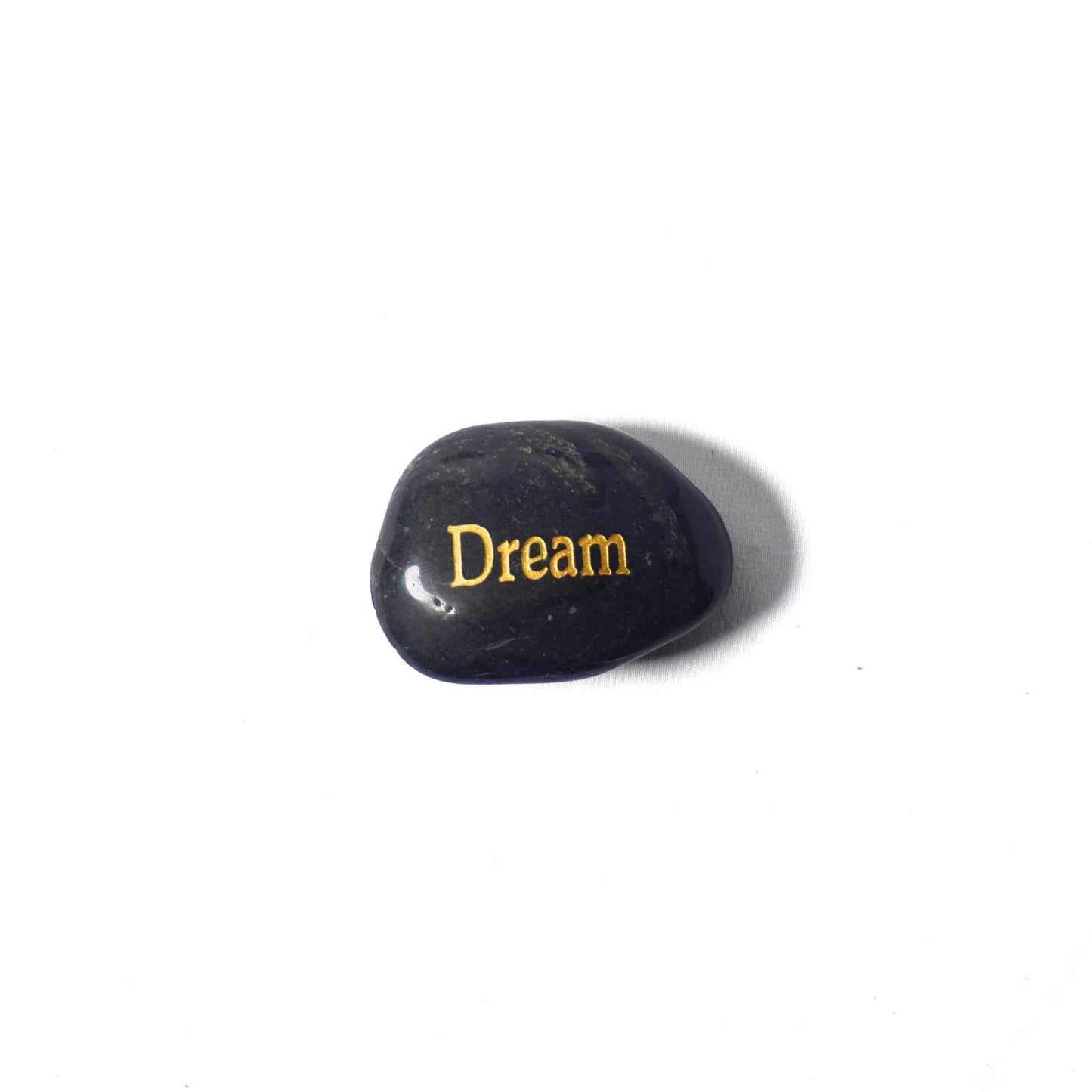 Black stone with 'Dream' engraved in gold on a white background