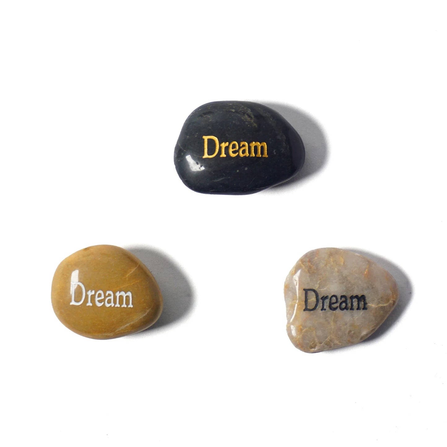 Three stones with 'Dream' engraved on them on a white background