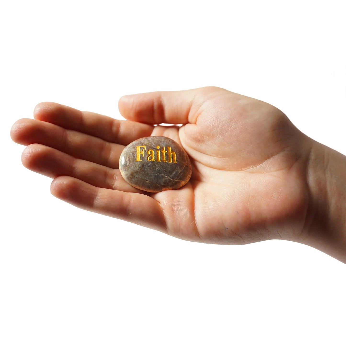 Hand holding a stone with 'Faith' engraved on it against a white background