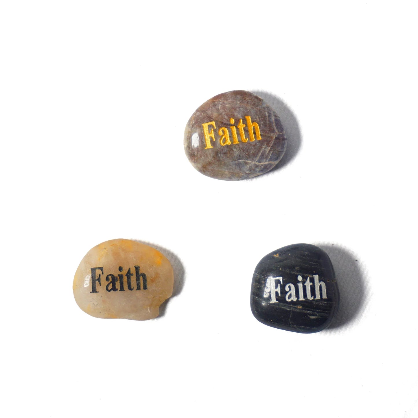 Three stones with 'Faith' engraved on them on a white background