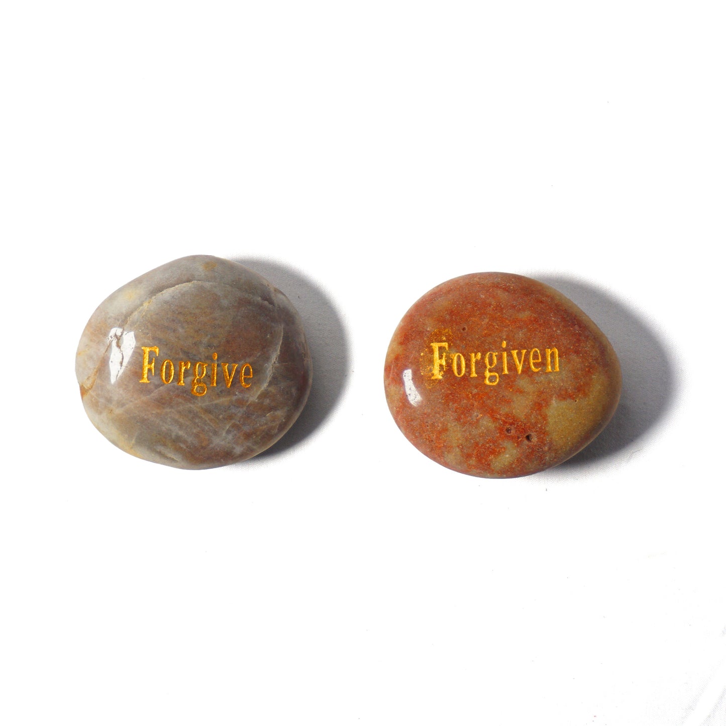 Two stones with 'Forgive' and 'Forgiven' engraved on a white background