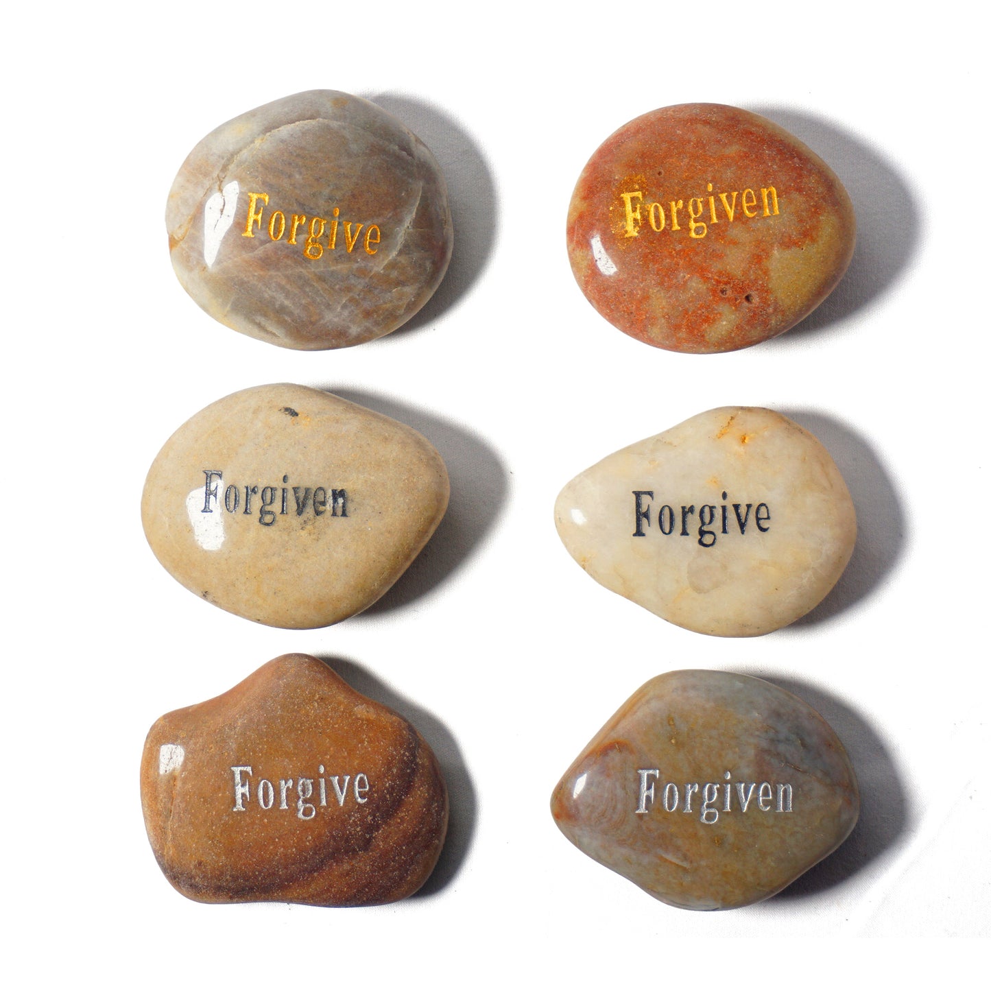 Set of six stones with 'Forgive' engraved on them, arranged in two rows on a white background.