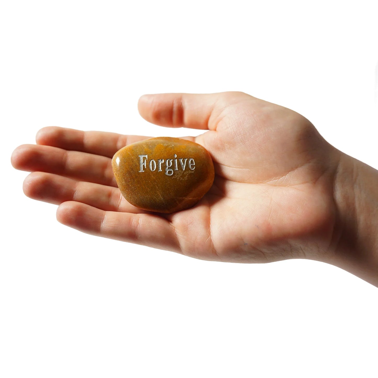 Hand holding a stone with 'Forgive' engraved on it against a white background