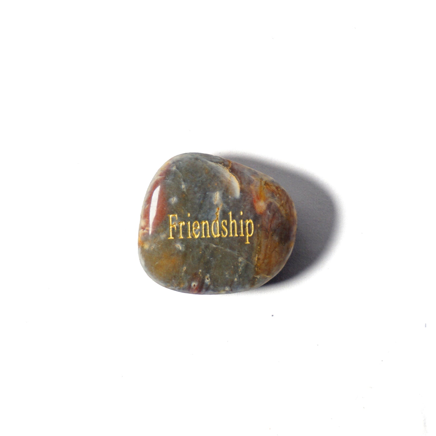 Polished stone with 'Friendship' engraved on a white background