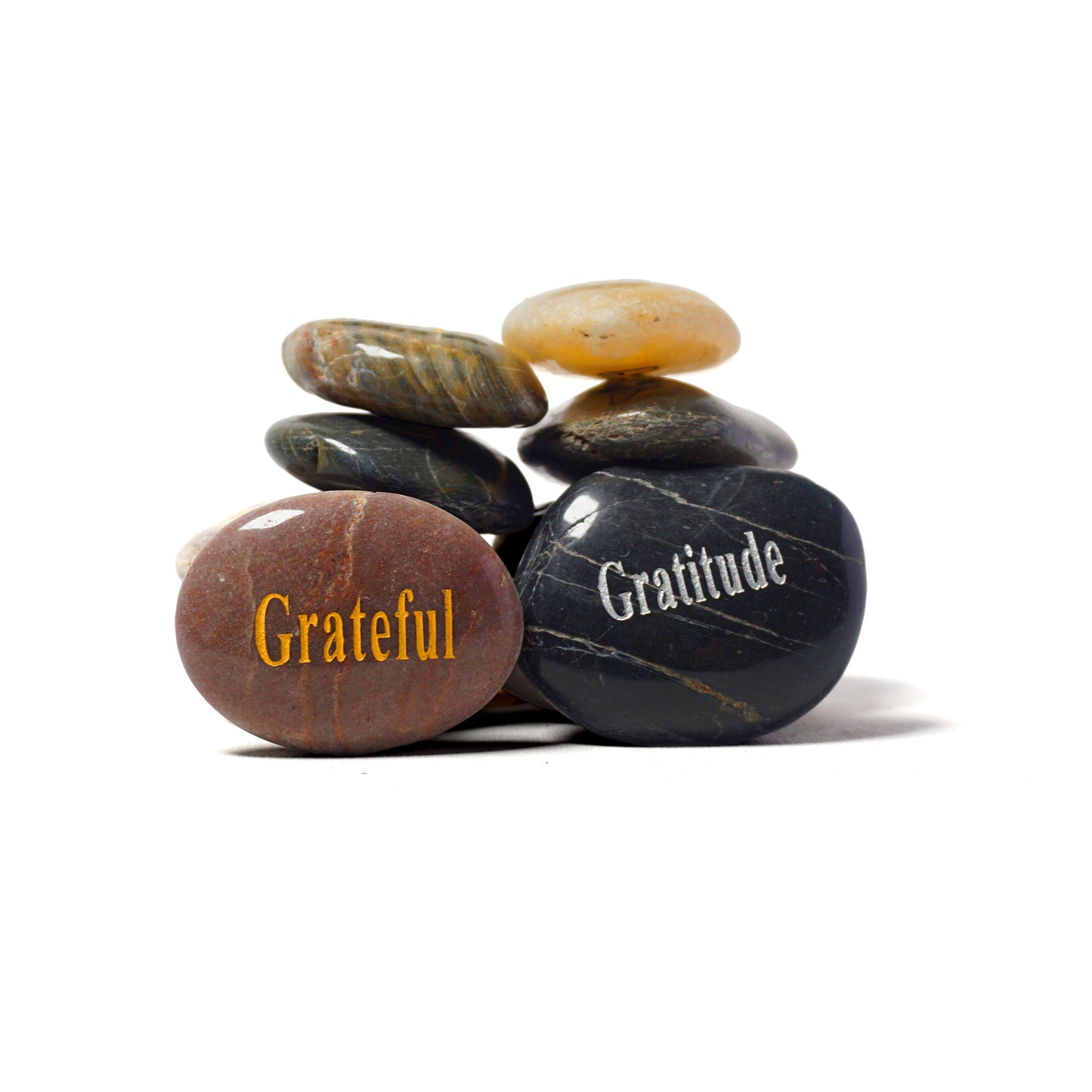 Stack of stones with 'Grateful' and 'Gratitude' inscriptions on a white background