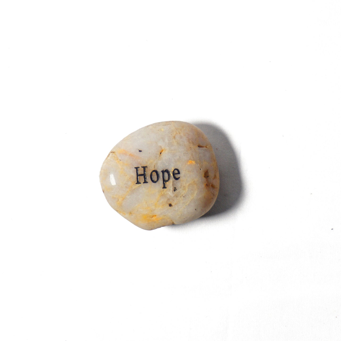 Round stone with 'Hope' engraved on a white background