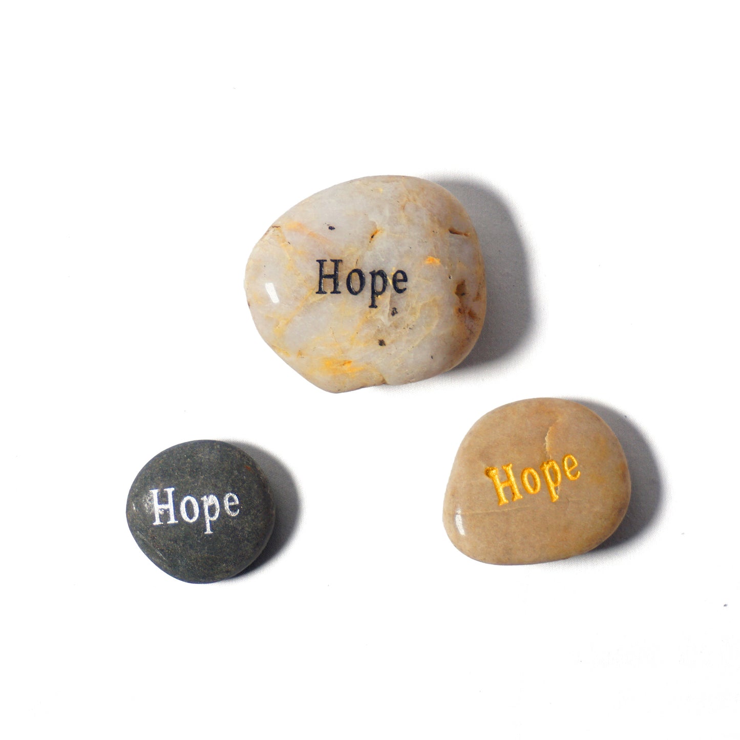 Three stones with 'Hope' engraved on them in different colors on a white background