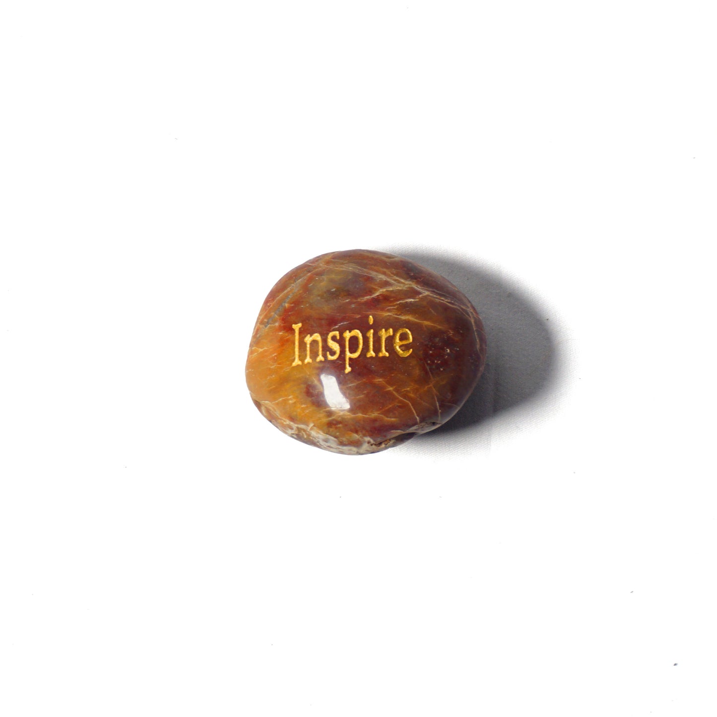 Brown stone with 'Inspire' engraved on a white background