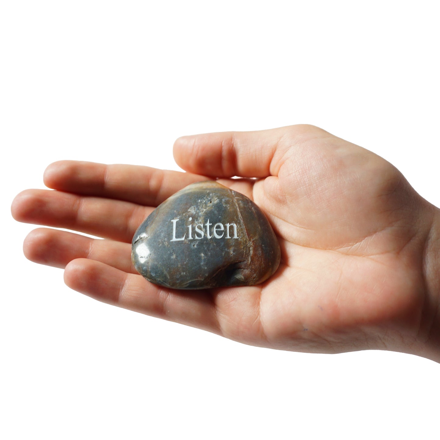 Hand holding a stone with 'Listen' engraved on it against a white background