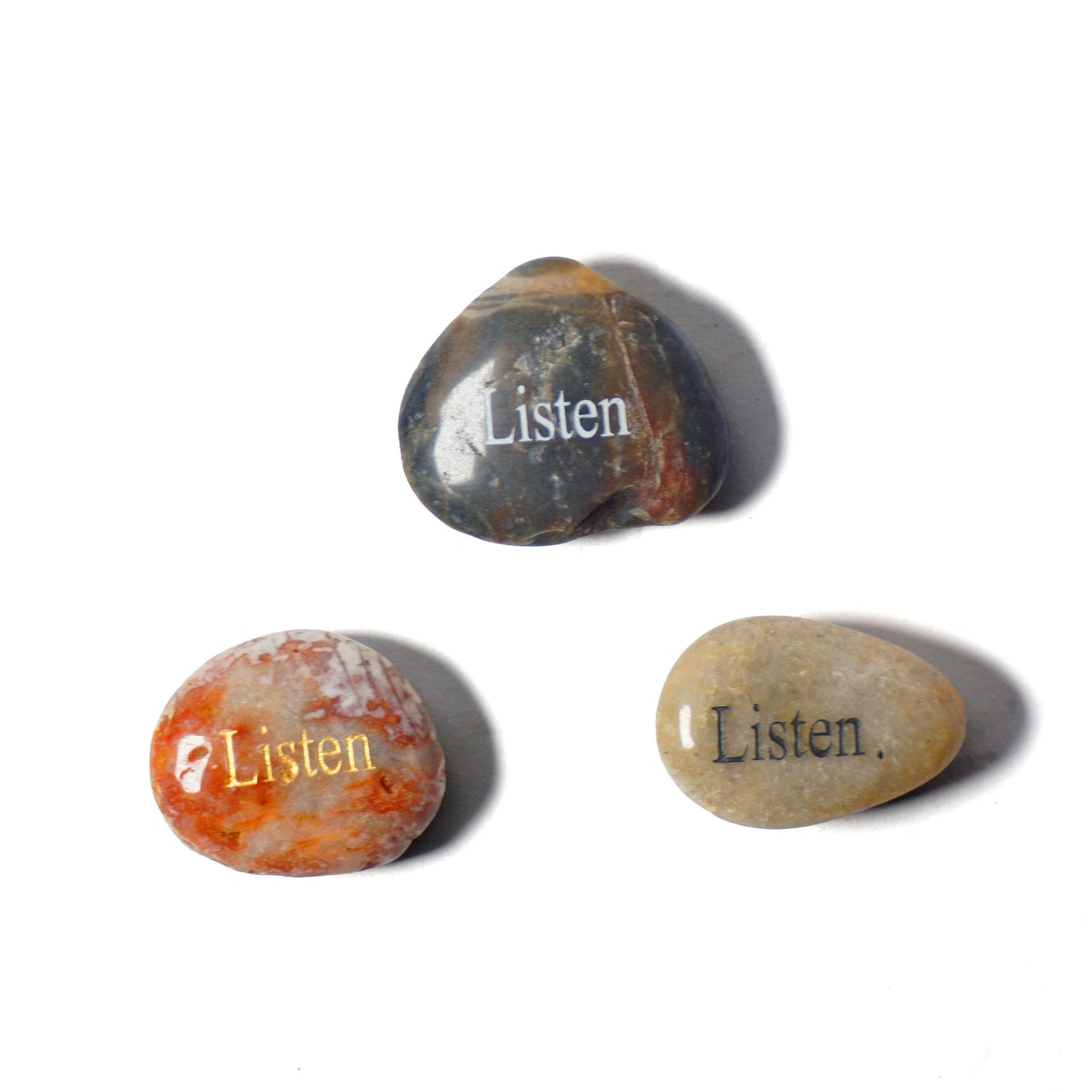 Three stones with 'Listen' engraved on them on a white background