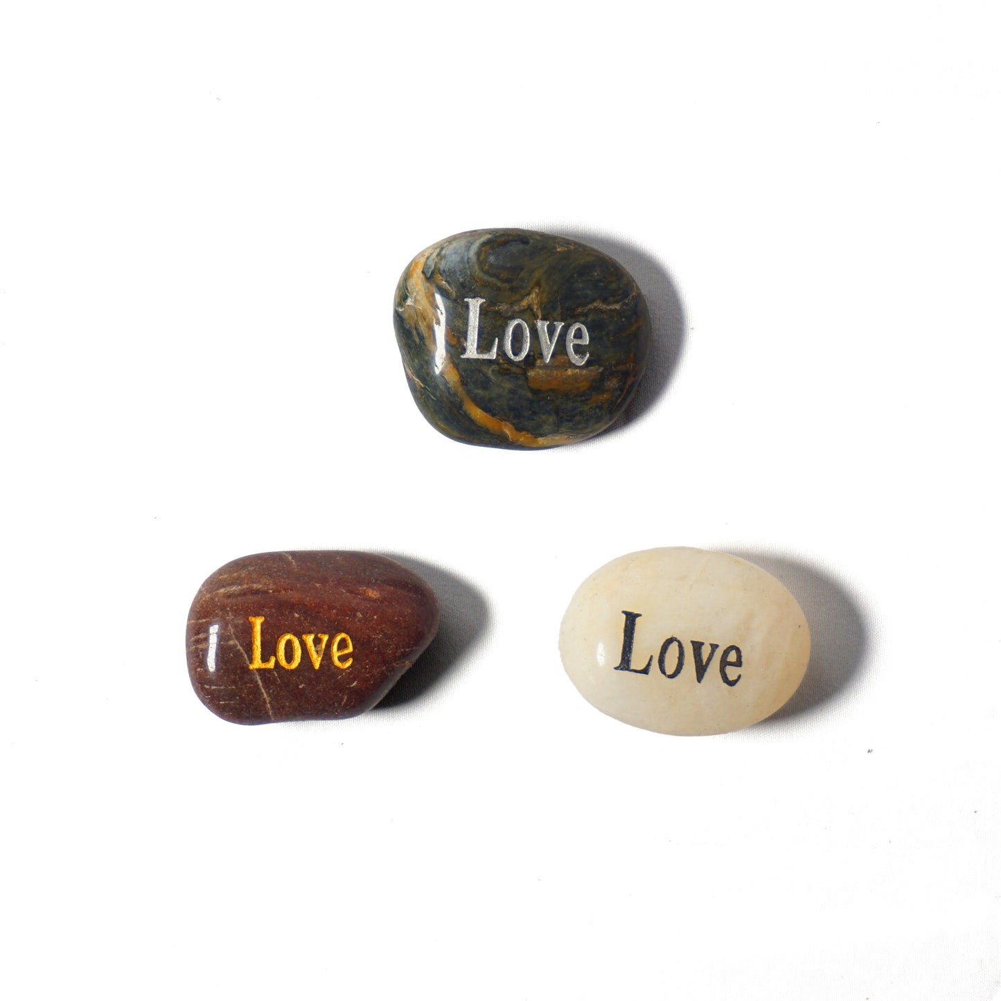 Three stones with 'Love' engraved on them on a white background