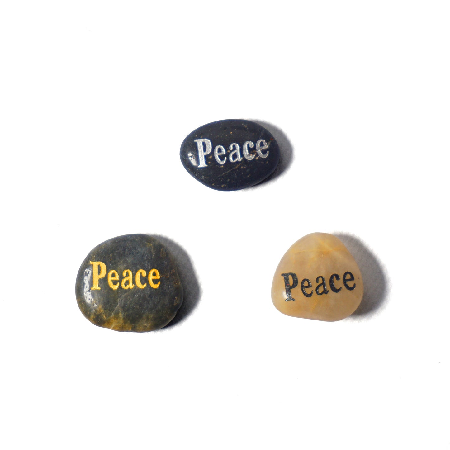 Three stones with 'Peace' engraved on them on a white background