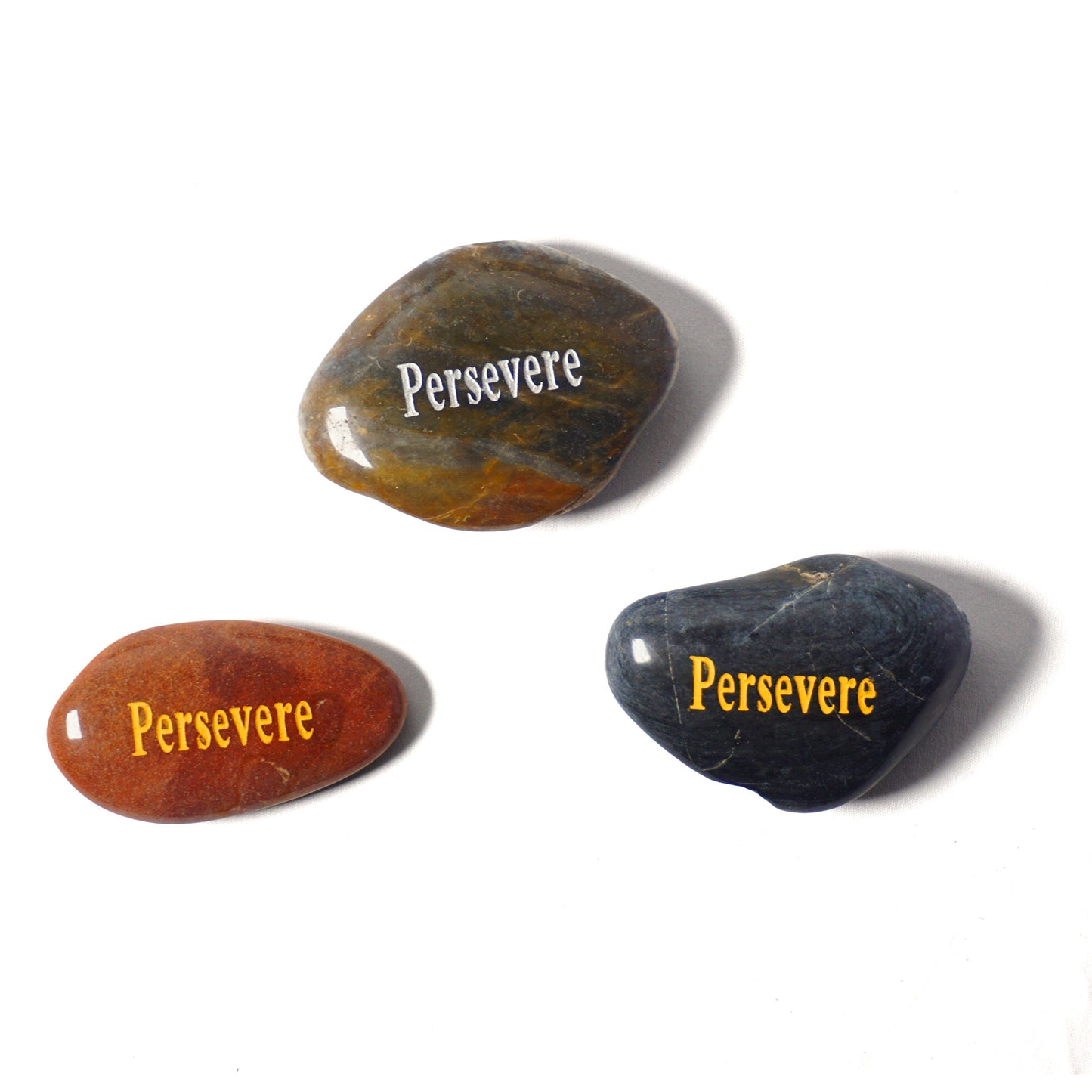 Three stones with 'Persevere' engraved on them on a white background
