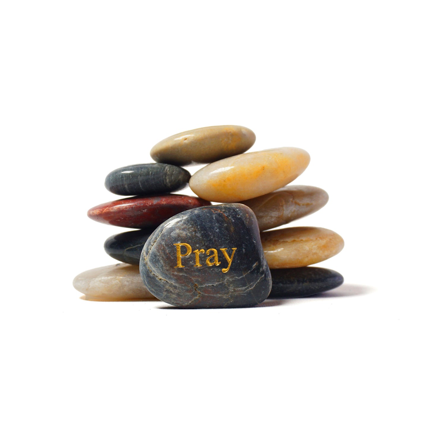 Stack of multicolored stones with 'Pray' engraved on one stone against a white background