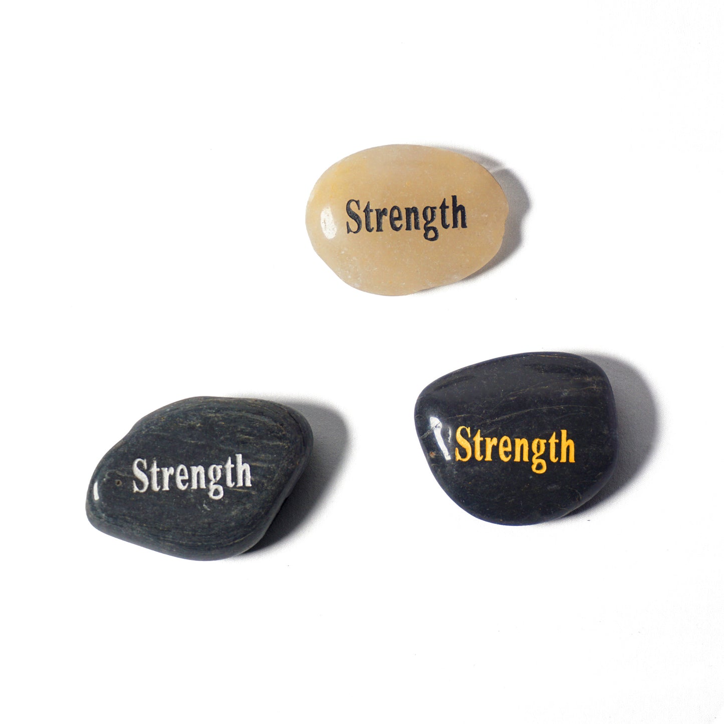 Three stones with 'Strength' engraved on them on a white background