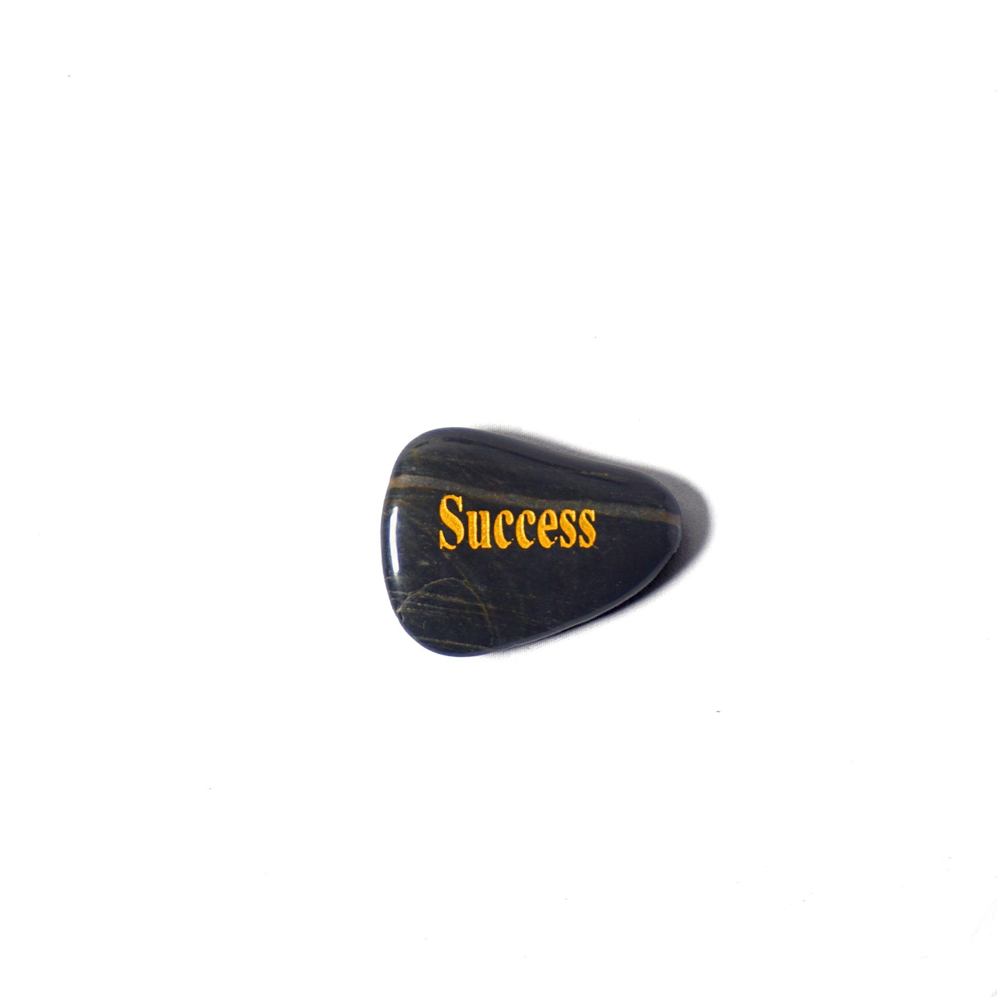 Black stone with 'Success' engraved in gold on a white background