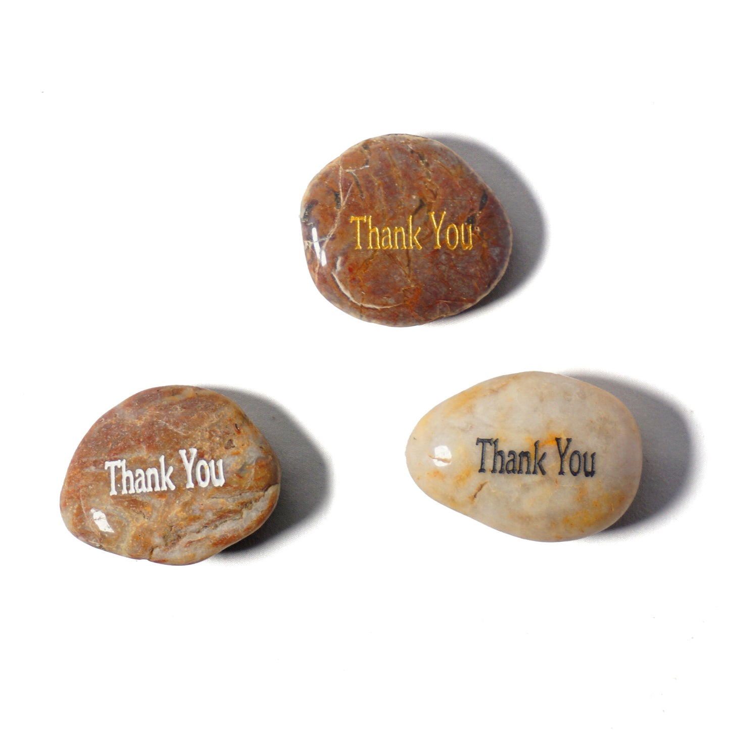 Three stones with 'Thank You' engraved on them on a white background