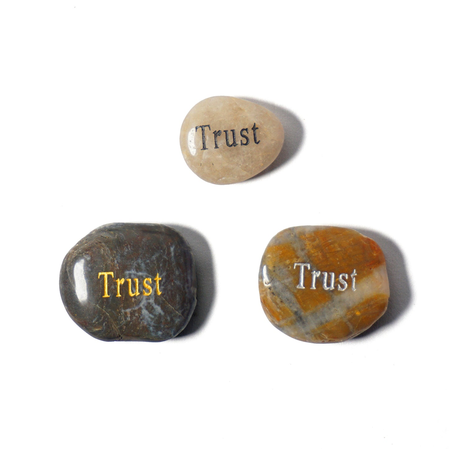 Three stones with 'Trust' engraved on them on a white background