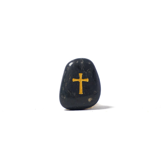 Black stone with a gold cross on a white background