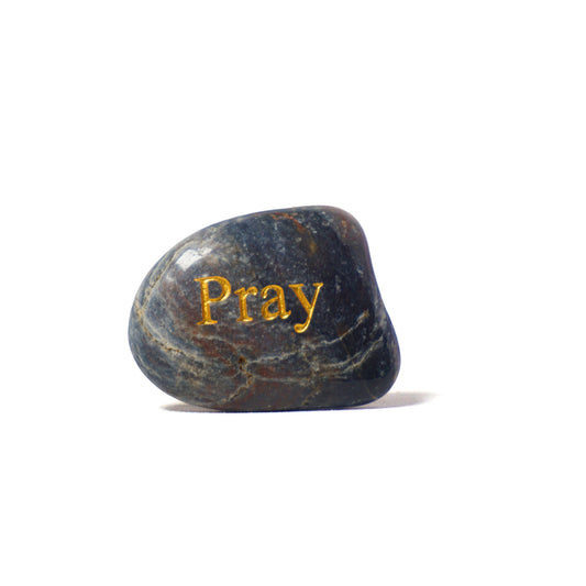Decorative stone with 'Pray' engraved on a white background