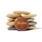 Stack of stones with a brown one labeled 'Wisdom' on a white background