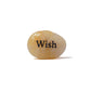Decorative stone with 'Wish' engraved on a white background