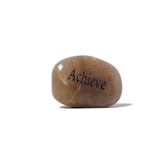 Brown stone with 'Achieve' engraved on a white background
