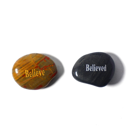 Two stones, one with 'Believe' and the other with 'Believed', on a white background.