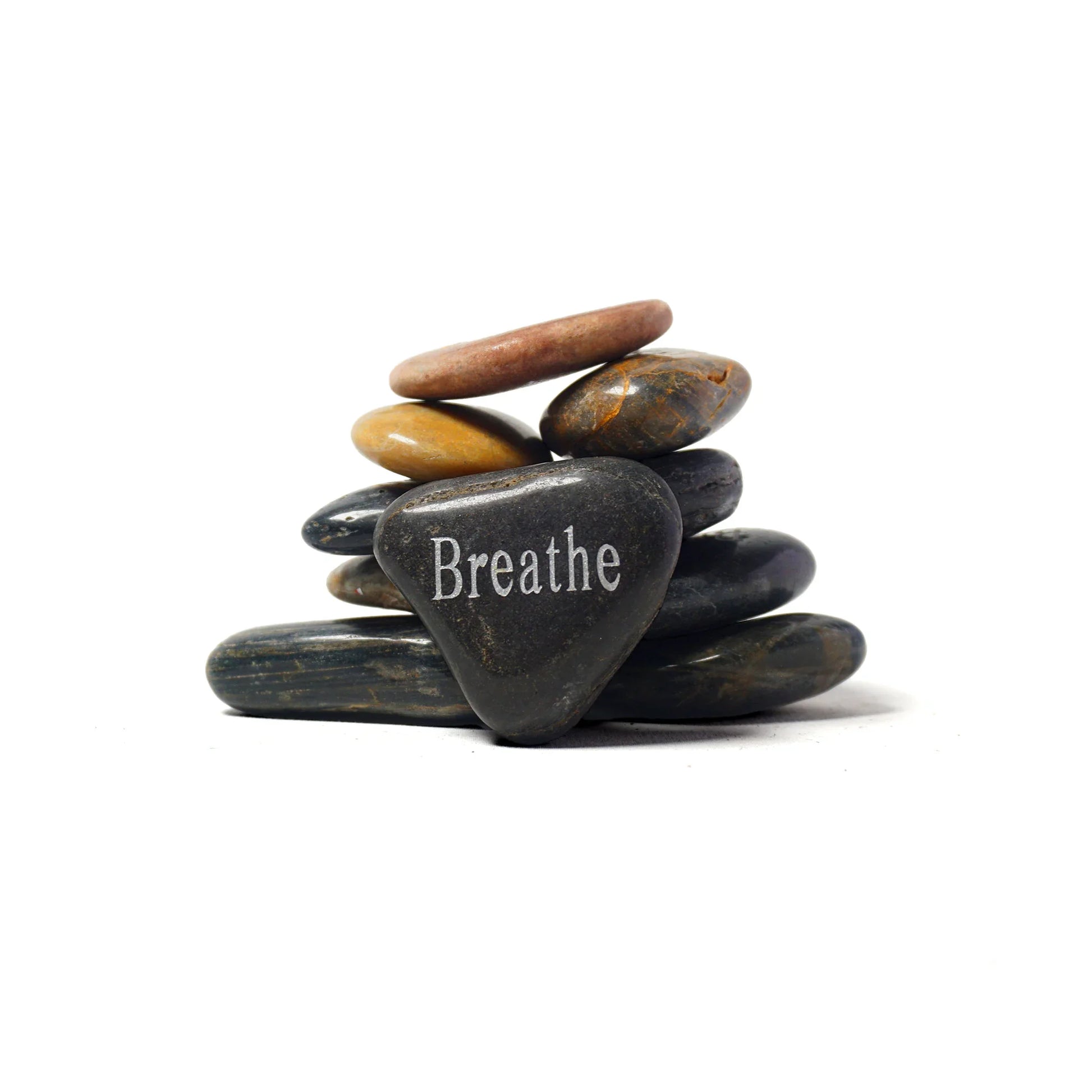 Stack of stones with a heart-shaped stone featuring the word 'Breathe' on a white background