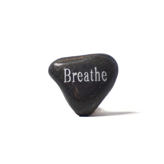 Black stone with 'Breathe' engraved on a white background